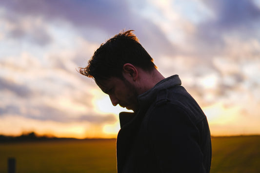 man in black coat looking at the sky during sunset