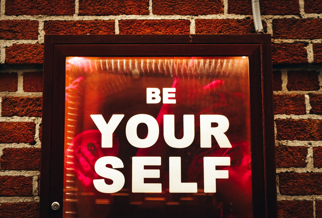 a sign that says be your self on a brick wall