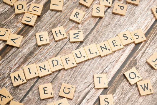 scrabble tiles spelling the word mindfulness on a wooden surface