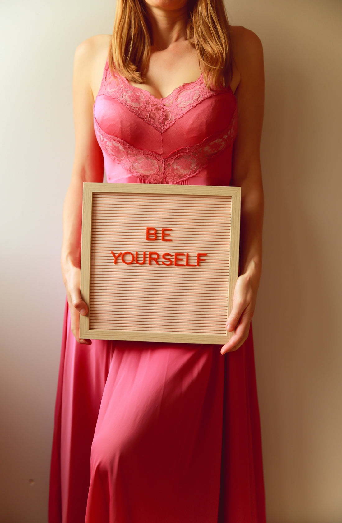 Woman holds a sign that reads, be yourself.