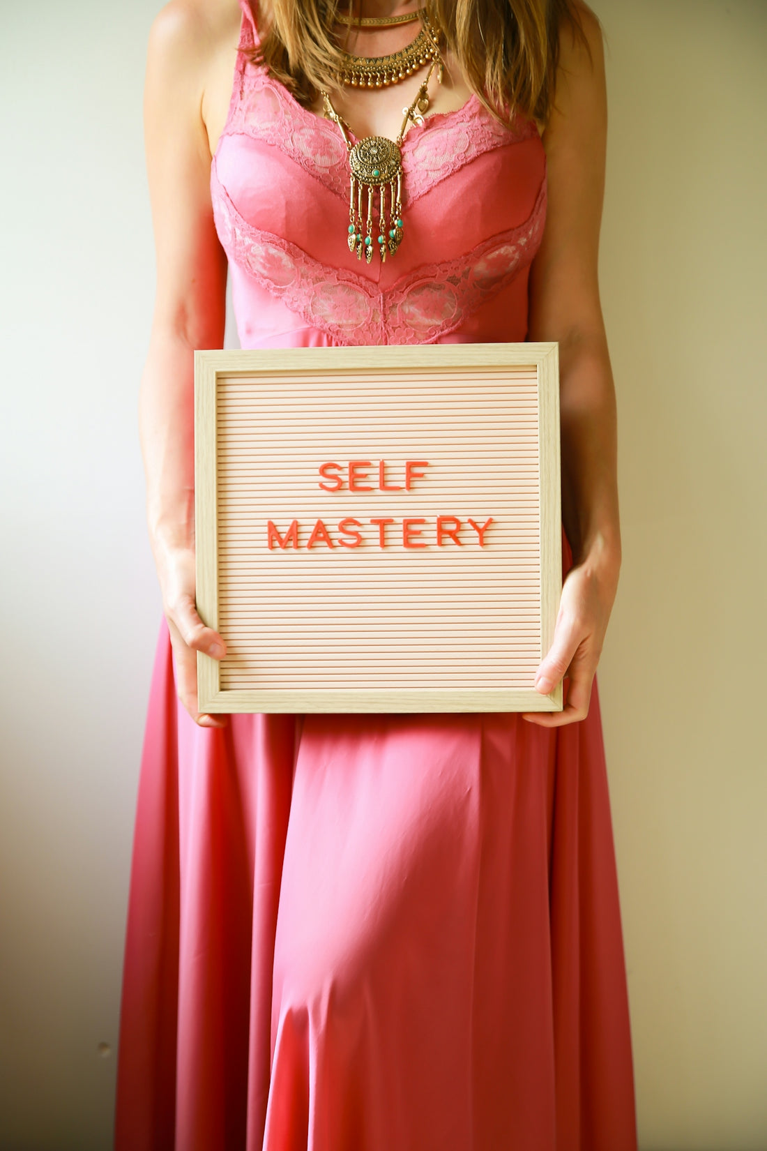 Woman holds a sign that says self mastery.
