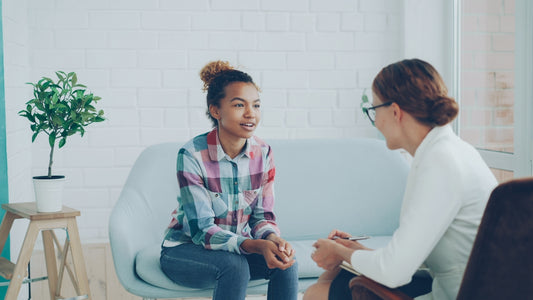 Two women talking in a modern office setting.